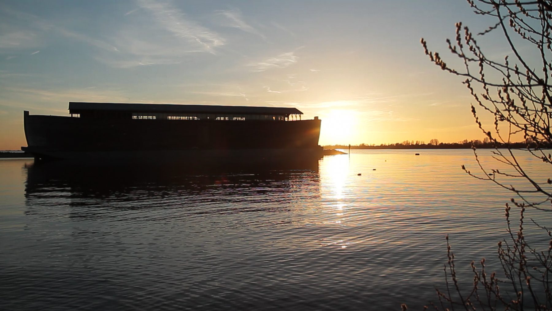 De Ark van Noach in de haven bij zonsondergang